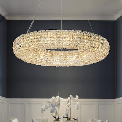 a chandelier hanging over a dining table in a room with blue walls and white chairs