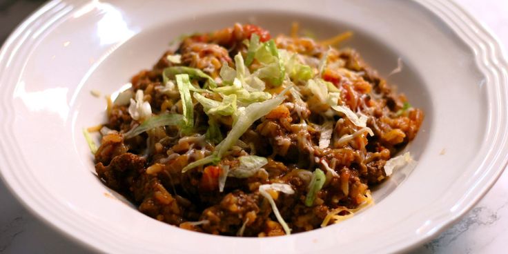 a white bowl filled with food on top of a table