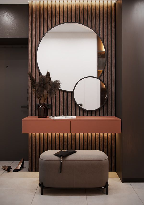 a modern dressing room with a round mirror on the wall and an ottoman in front of it