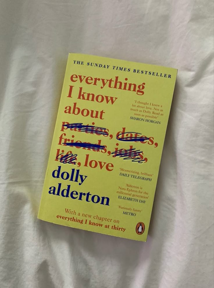 the book everything i know about fire, love and dolly alderon is laying on a white sheet