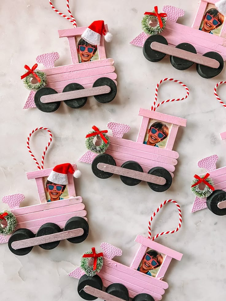 pink wooden train ornament with santa's hat on top and candy canes attached to it