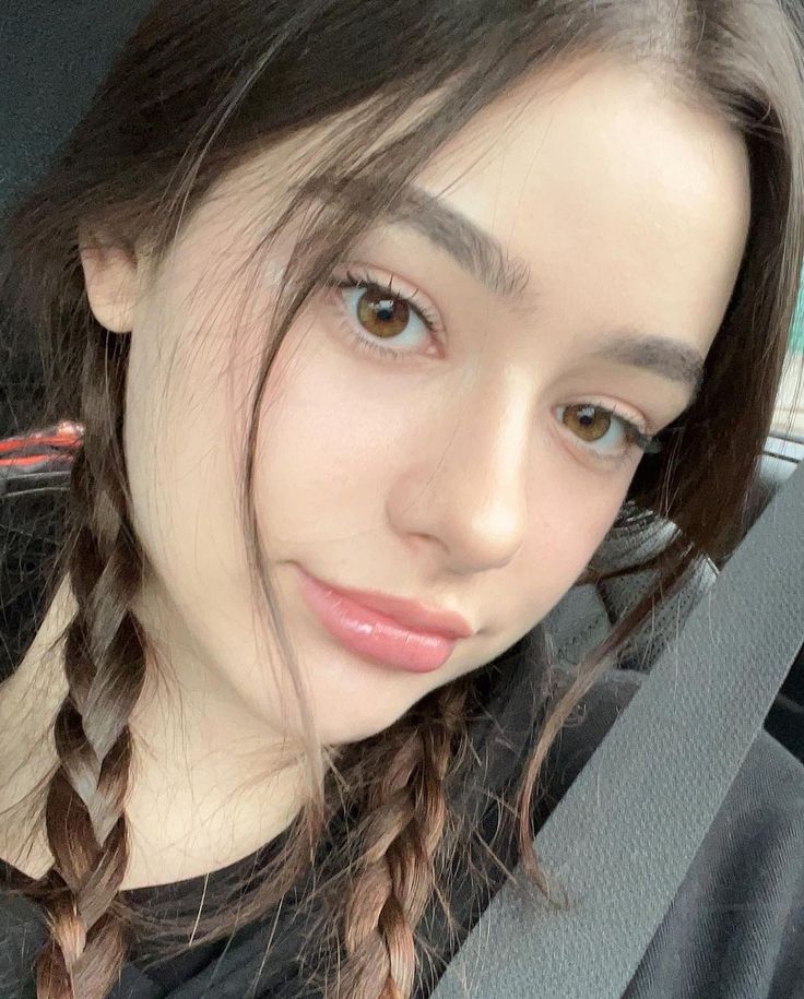 a woman with braids in her hair sitting in a car