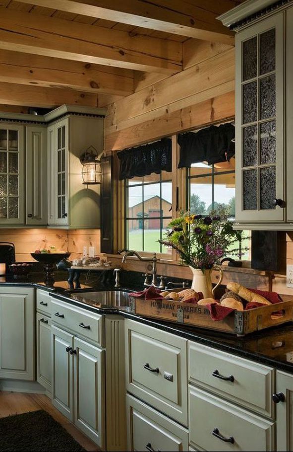 a large kitchen with white cabinets and black counter tops, along with an island in the middle