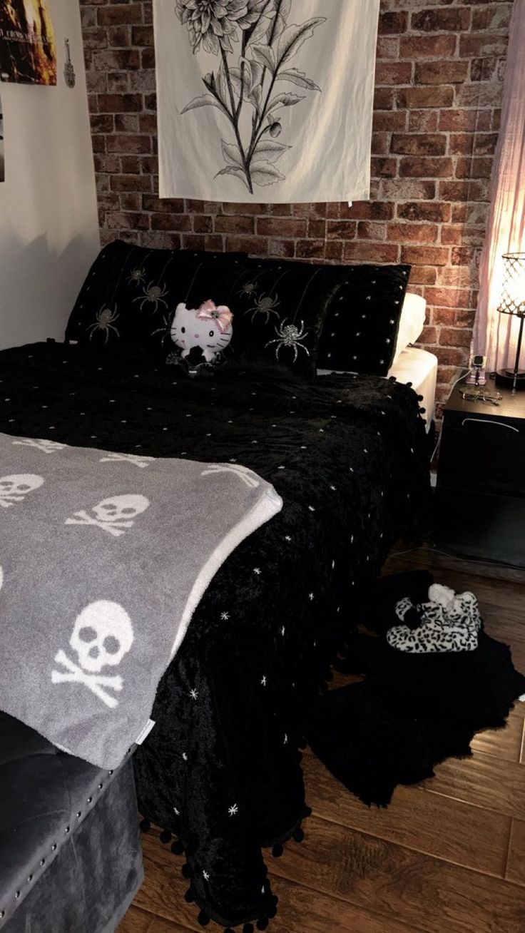 a bed with a skull and crossbones blanket on top of it next to a brick wall