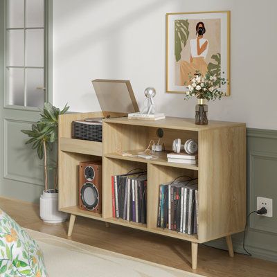 an open book shelf with books and other items on it in a living room next to a bed