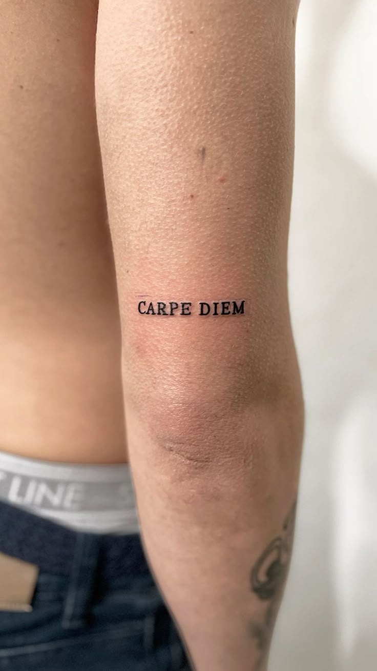 a man with a tattoo on his arm that says carpe diem in black ink