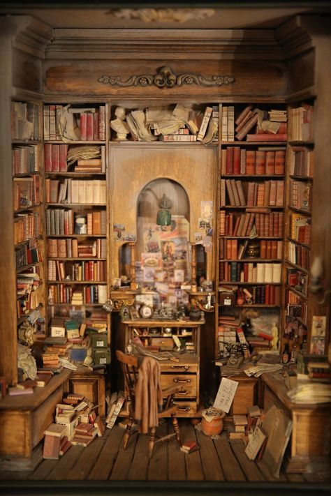 a room filled with lots of books next to a desk and shelves full of books