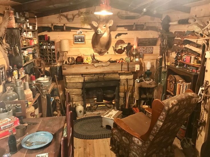 a living room filled with furniture and a fire place covered in deer head mounted on the wall