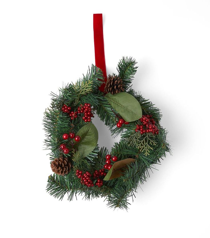 a christmas wreath hanging on a red ribbon