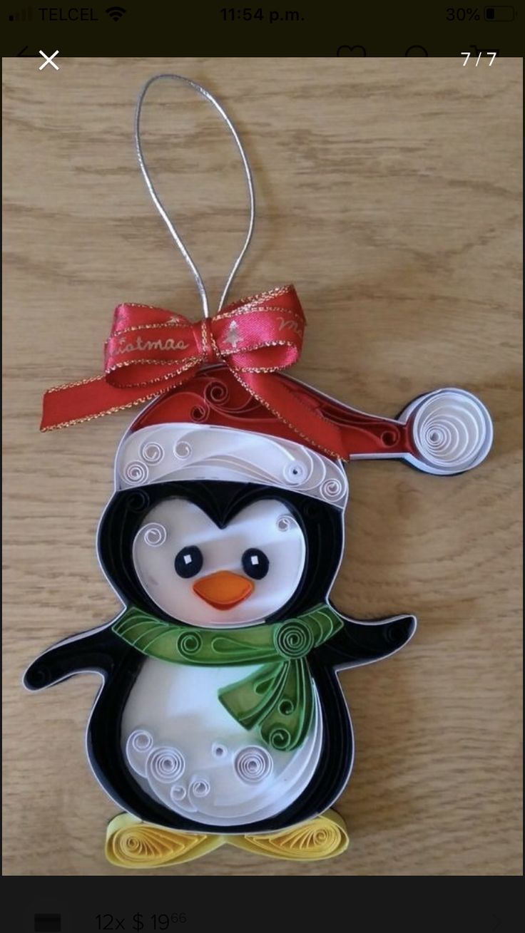 a christmas ornament with a penguin wearing a hat and scarf