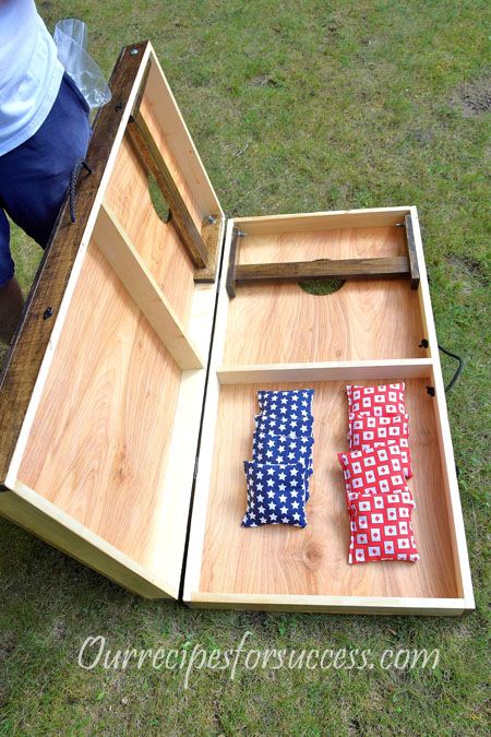 an open wooden box with ties in it on the ground next to some green grass