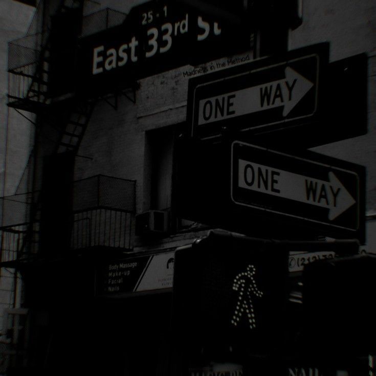 black and white photograph of street signs in front of an east 33rd st apartment building