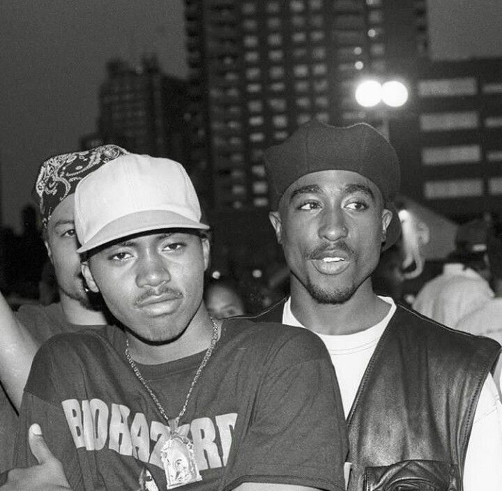 two young men standing next to each other in front of a city skyline at night