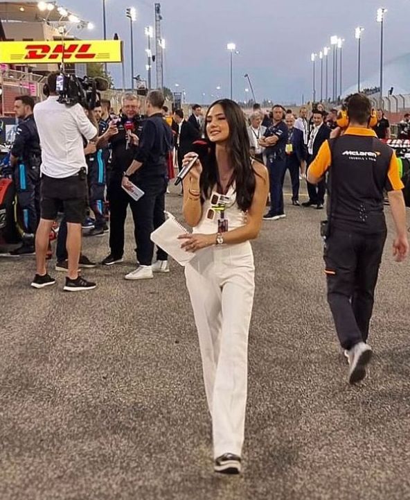 a woman is walking in the middle of a race track