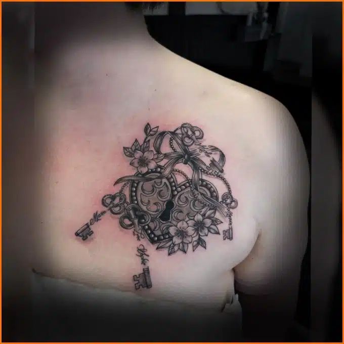 the back of a woman's shoulder with flowers and keys on it