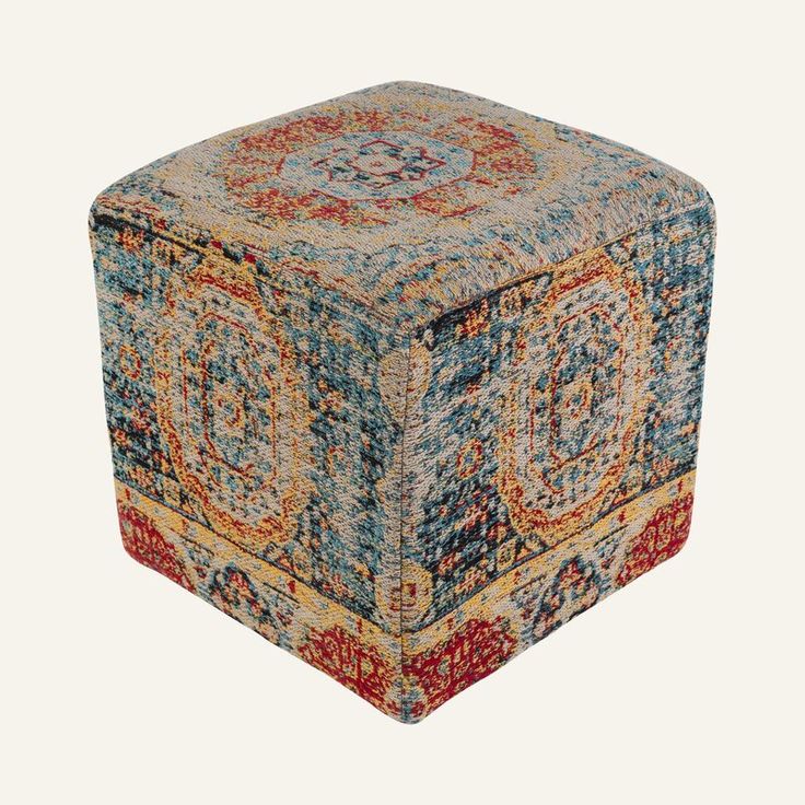 a multicolored square ottoman sitting on top of a white floor