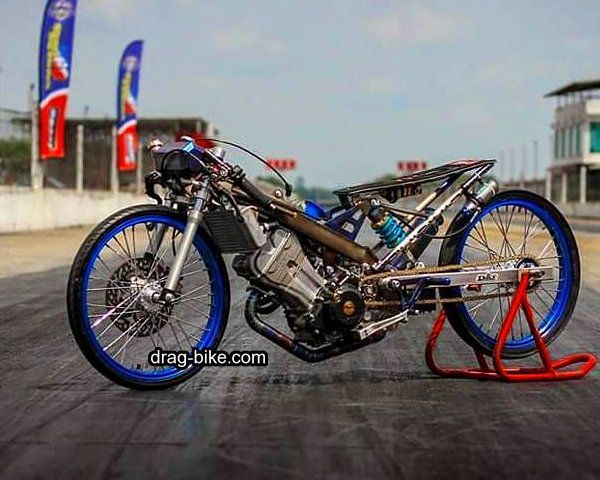 a motorcycle with blue rims parked on top of a street next to a building