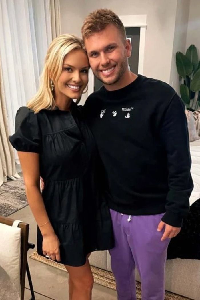 a man and woman standing next to each other in front of a living room couch