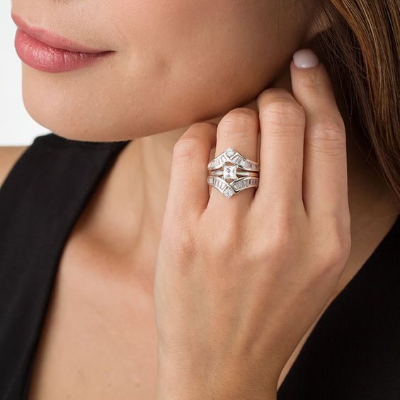 a woman wearing a black top with a ring on her left hand and a diamond set in the middle