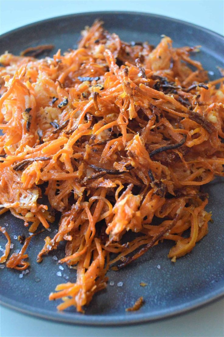 shredded carrots on a blue plate sitting on a table