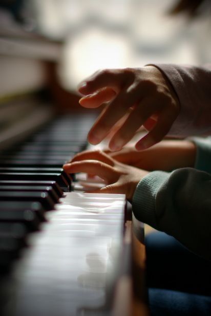 two hands are playing the piano together