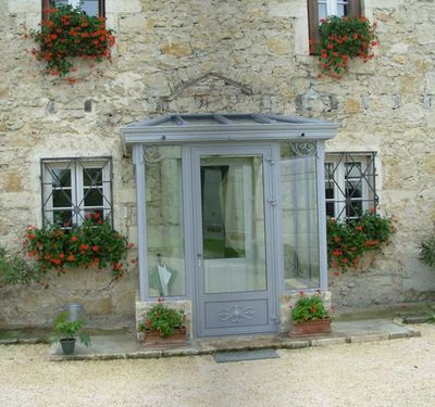 an old stone building with potted flowers on the windows