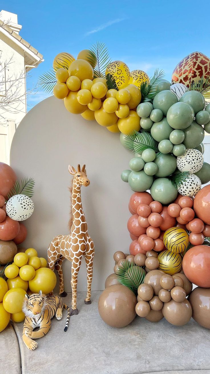 a fake giraffe is standing in front of balloons