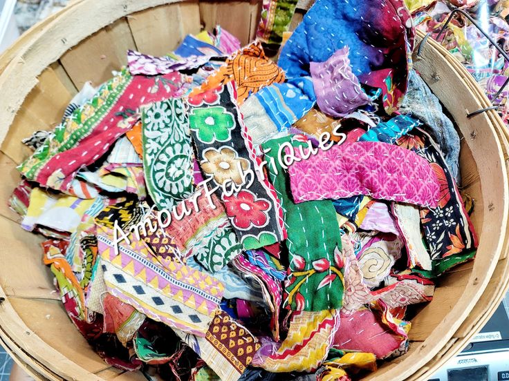 a wooden basket filled with lots of colorful fabric