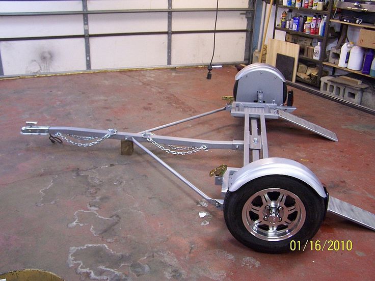 the trailer is parked in the garage with chains on it's sides and wheels