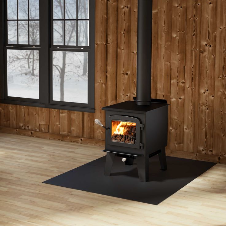 a wood burning stove in a room with wooden walls and flooring on the side