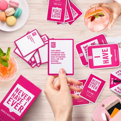 pink and white business cards with the words never have ever printed on them are being held by a woman's hand