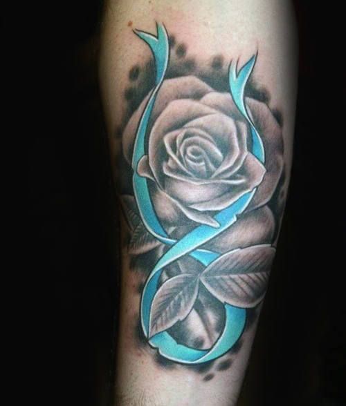 a black and grey rose with blue ribbon on the arm, done by tattoo artist person