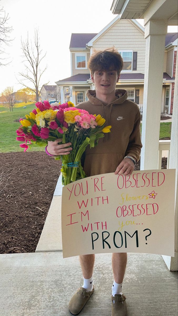 a boy holding flowers and a sign that says, you're obesed with i'm obsesed with prom