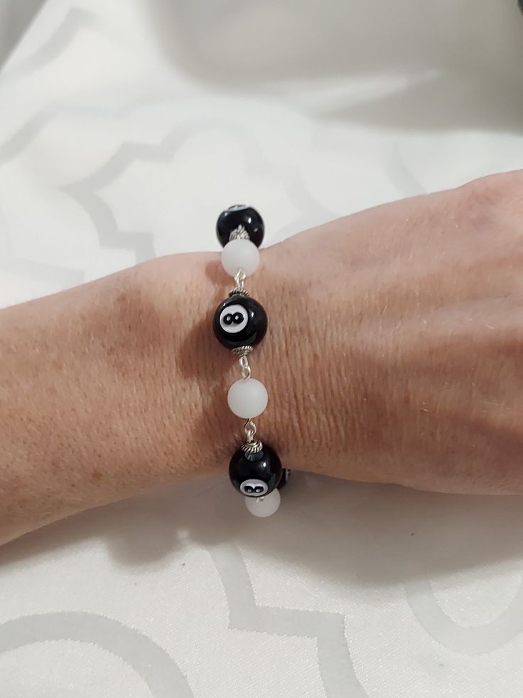 a woman's arm with a bracelet made out of black and white beads