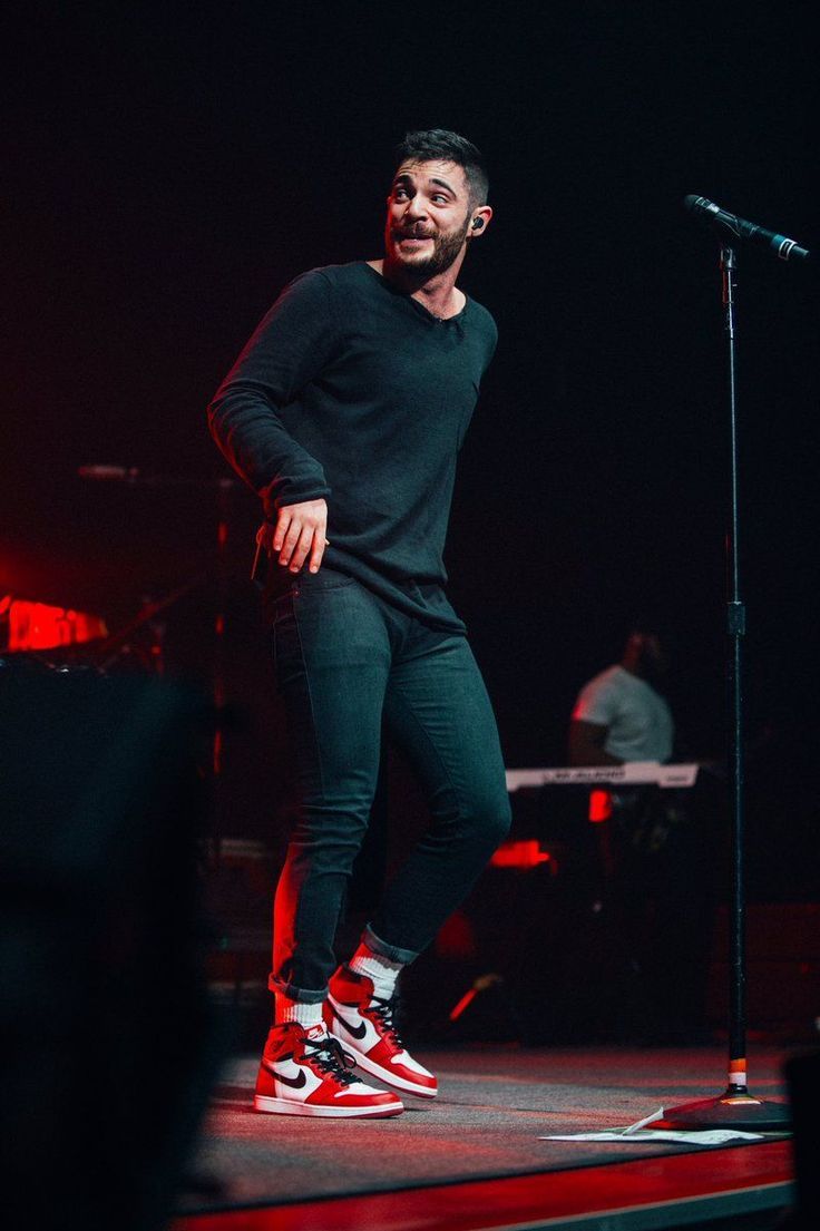 a man standing on top of a stage next to a microphone