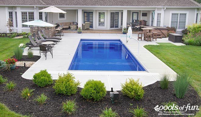 a backyard with a swimming pool and patio furniture