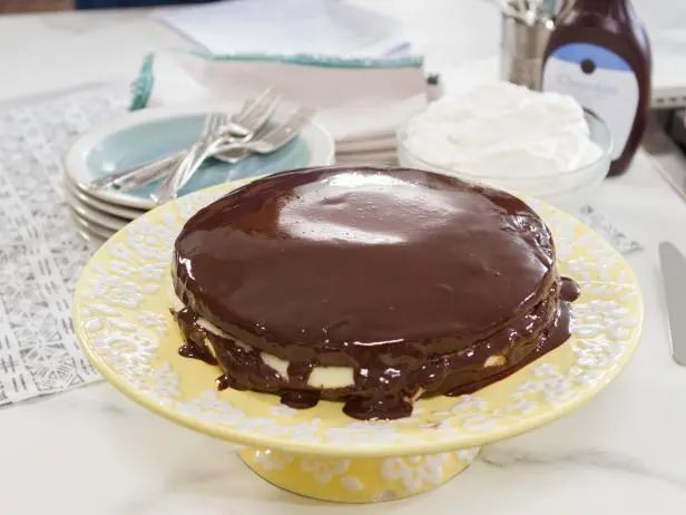 a chocolate cake sitting on top of a yellow and white plate next to silverware