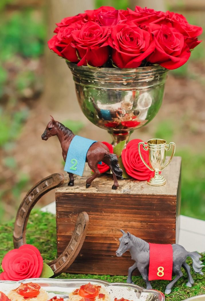 there is a small horse on top of a wooden box with flowers in the vase