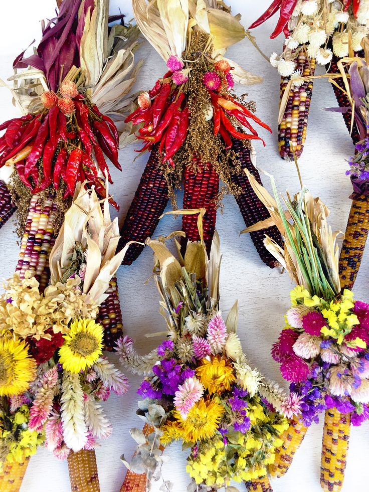 several corn cobs with dried flowers in them