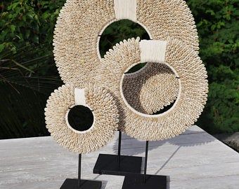 a sculpture made out of woven material sitting on top of a wooden table next to trees