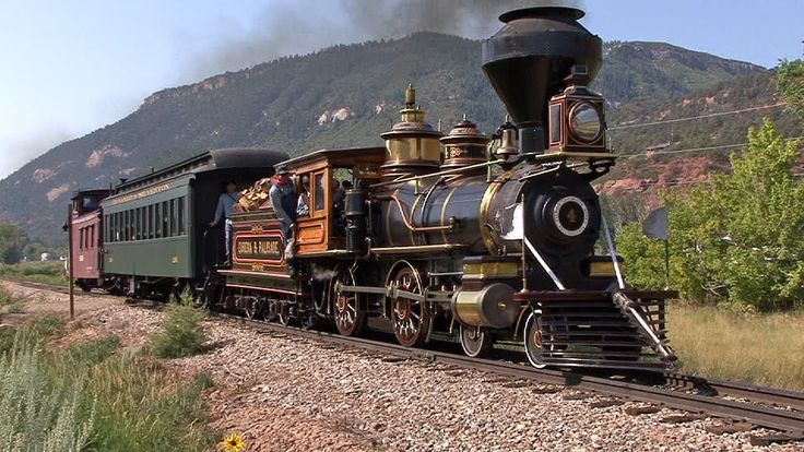 an old fashioned steam train traveling down the tracks