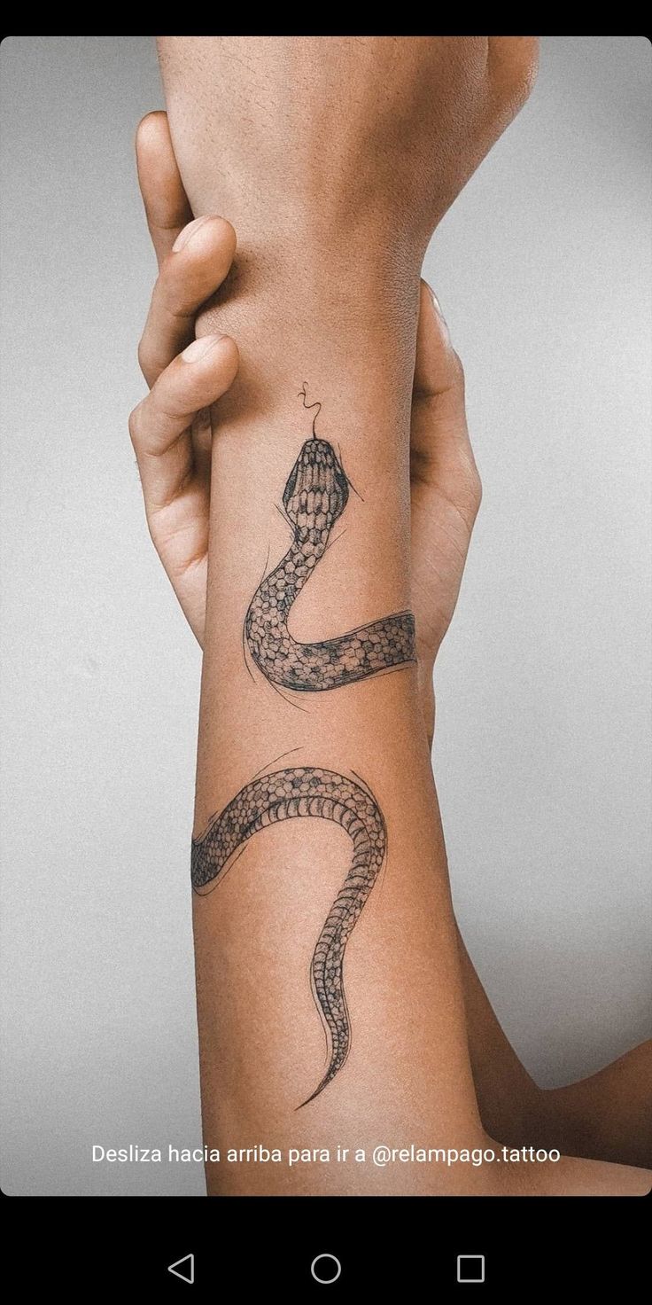 a woman's arm with a snake tattoo on it