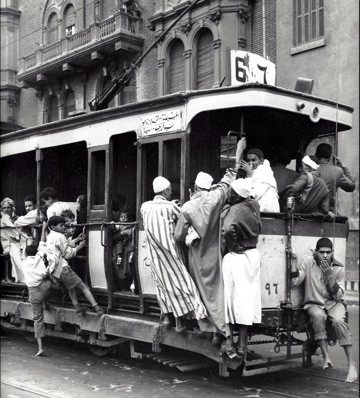 an old black and white photo of people on a trolley