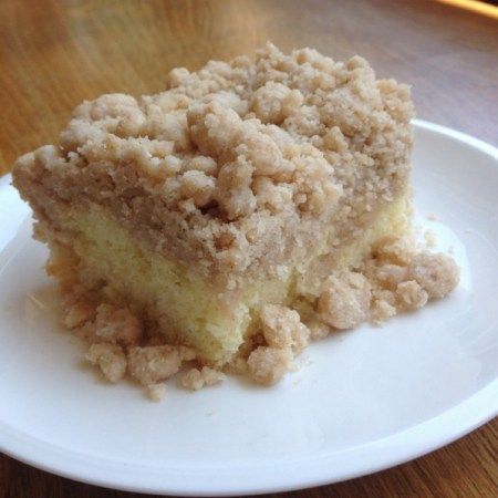 a close up of a piece of cake on a plate with crumb toppings