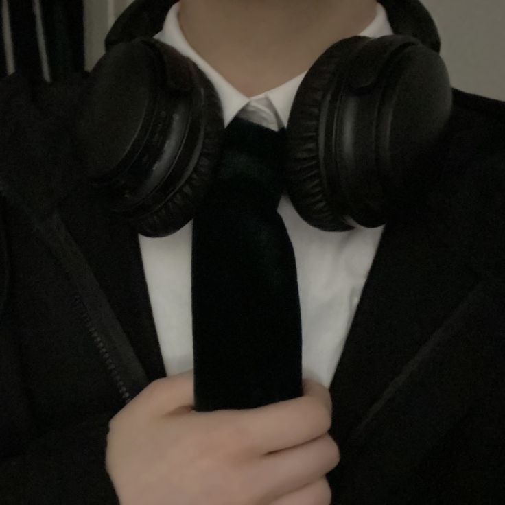 a man wearing headphones and a black tie