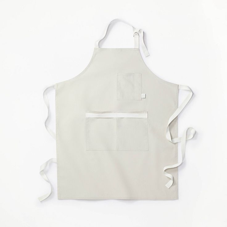 the apron is white and has an open pocket on one side with two pockets at the front