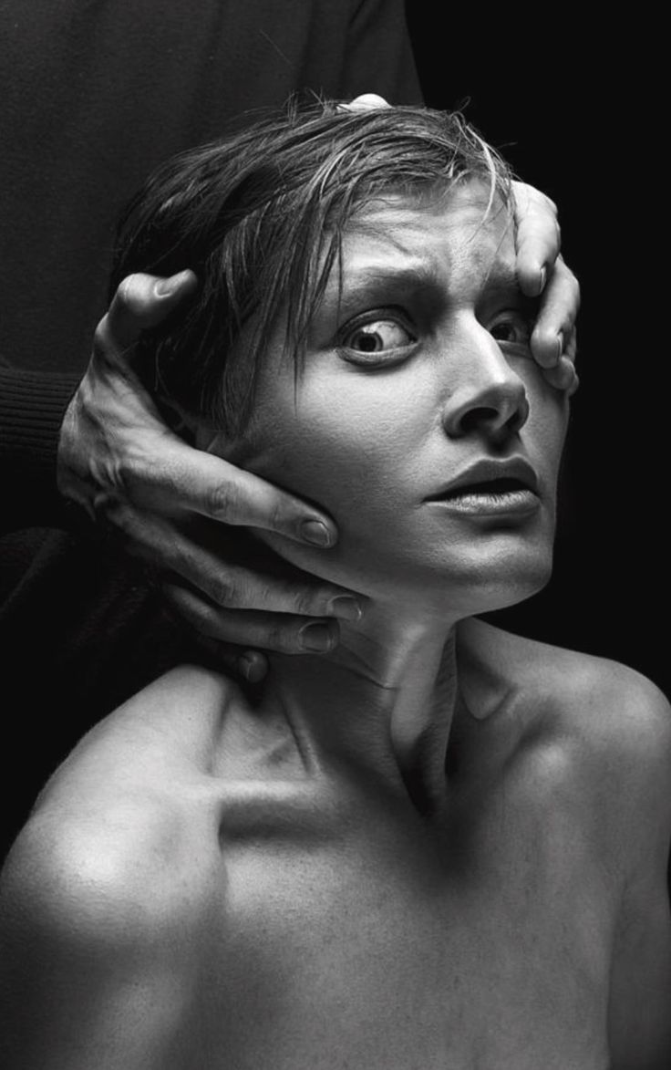 black and white photograph of a naked woman with hands on her head