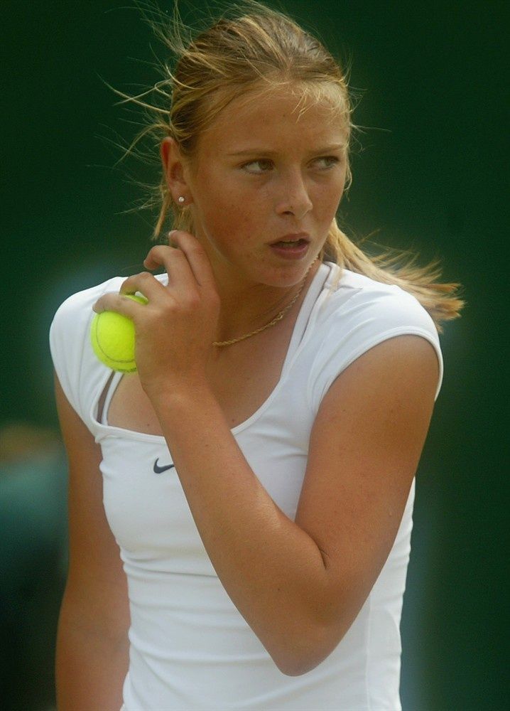 a woman holding a tennis ball and racket