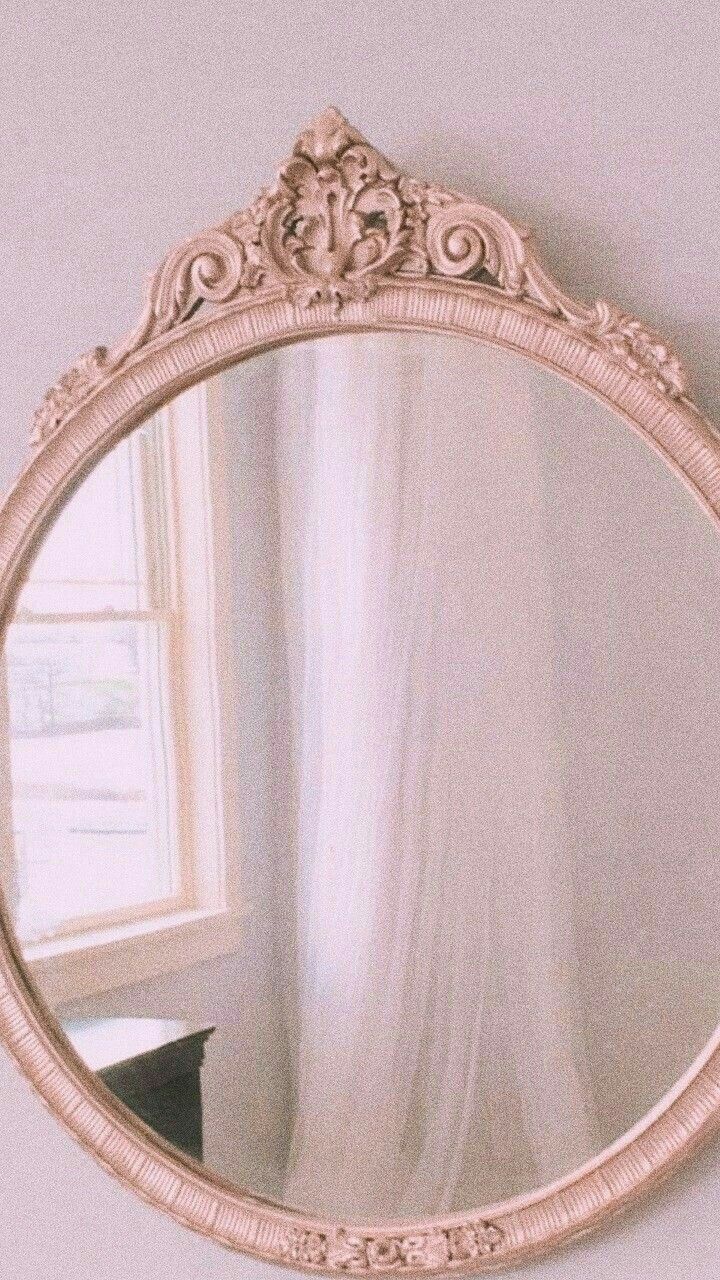 a mirror hanging on the wall in front of a window