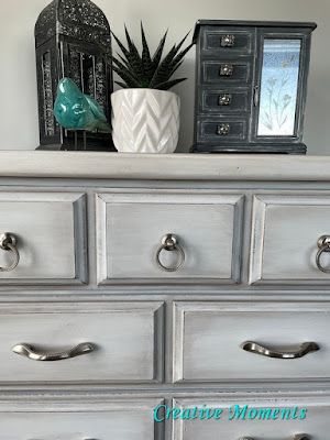 a white dresser with silver handles and drawers